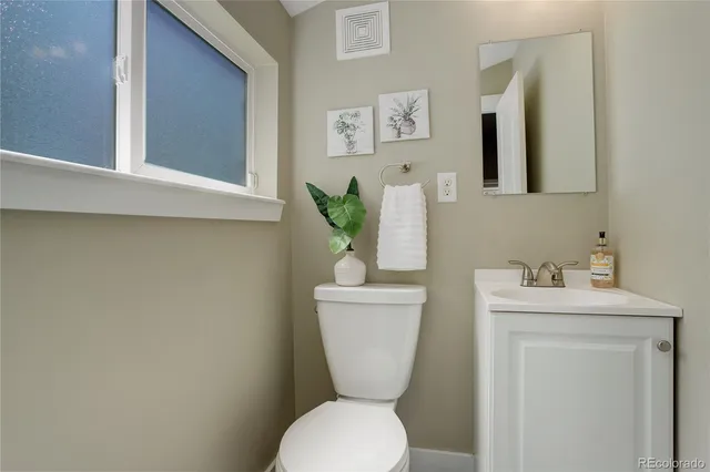 a bathroom with a toilet a sink and mirror