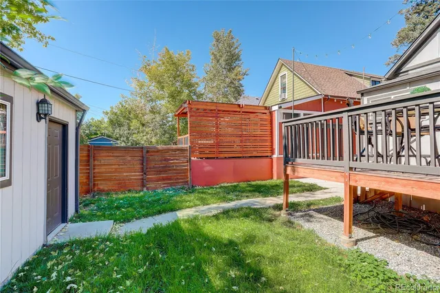 a view of backyard with deck and garden