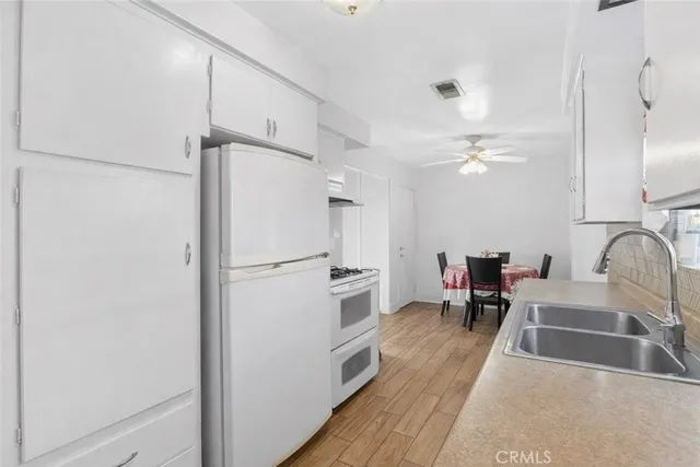 a kitchen with a sink cabinets and wooden floor