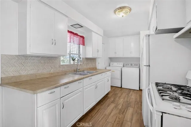 a kitchen with sink cabinets and wooden floor