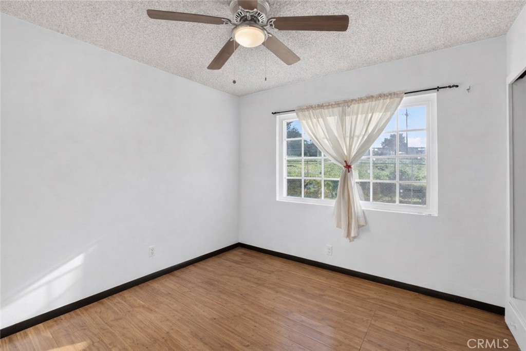 1650 Orange Street Riverside, CA 92501 - Photo 19 of 60 an empty room with wooden floor chandelier fan and windows