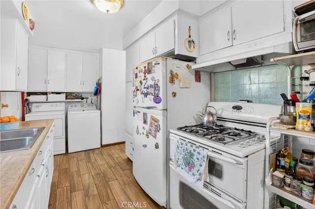 a view of a kitchen with fridge and workspace
