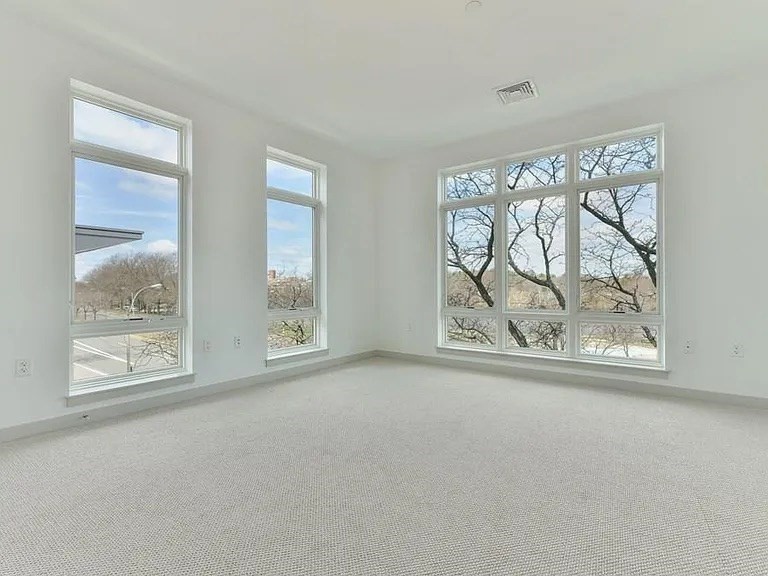 180 Telford Street, Unit 321 Boston, MA 02135 - Photo 8 of 10 an empty room with windows and view of wooden floor