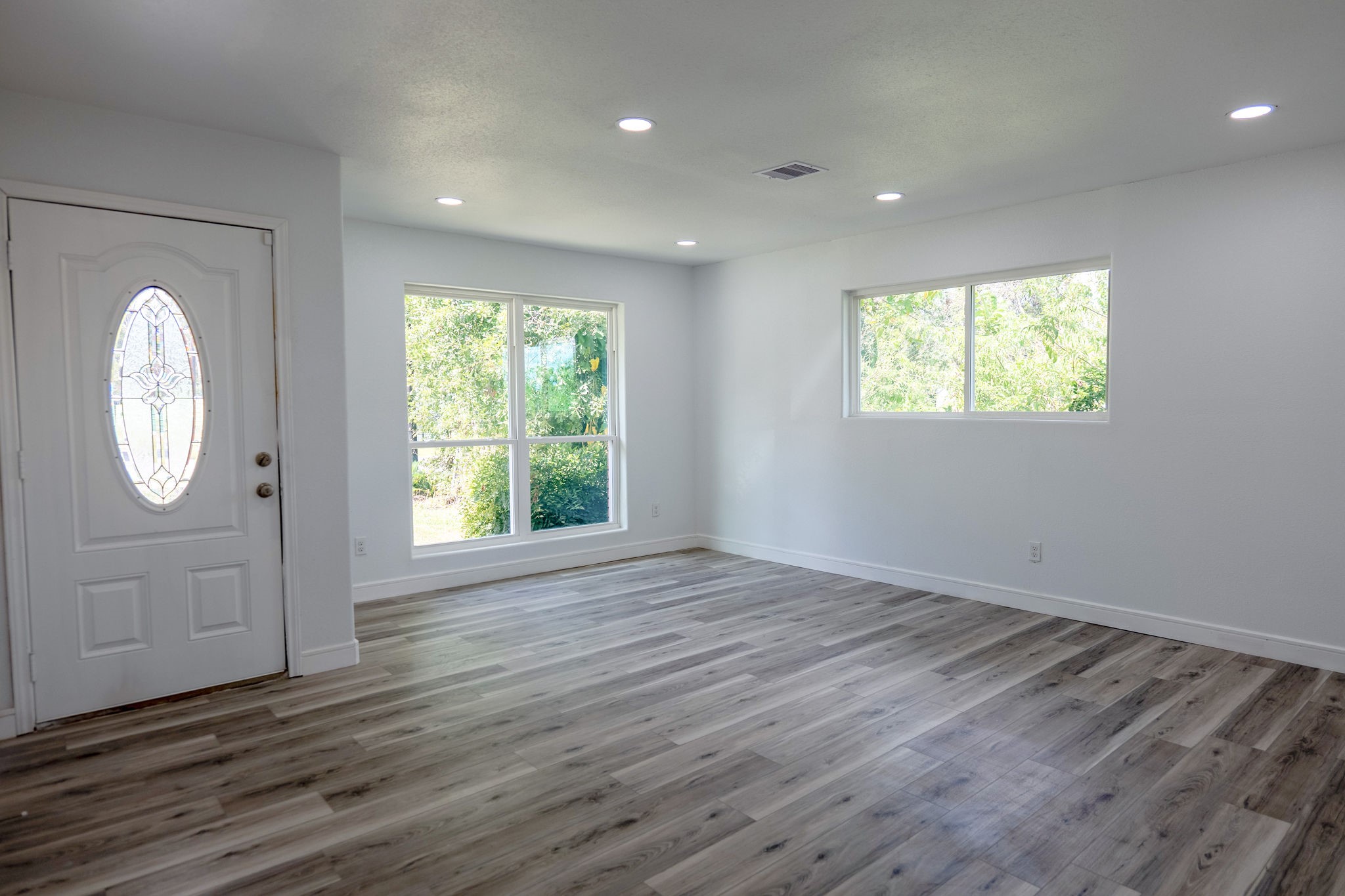 8718 Magna Street Houston, TX 77093 - Photo 4 of 33 an empty room with wooden floor and windows