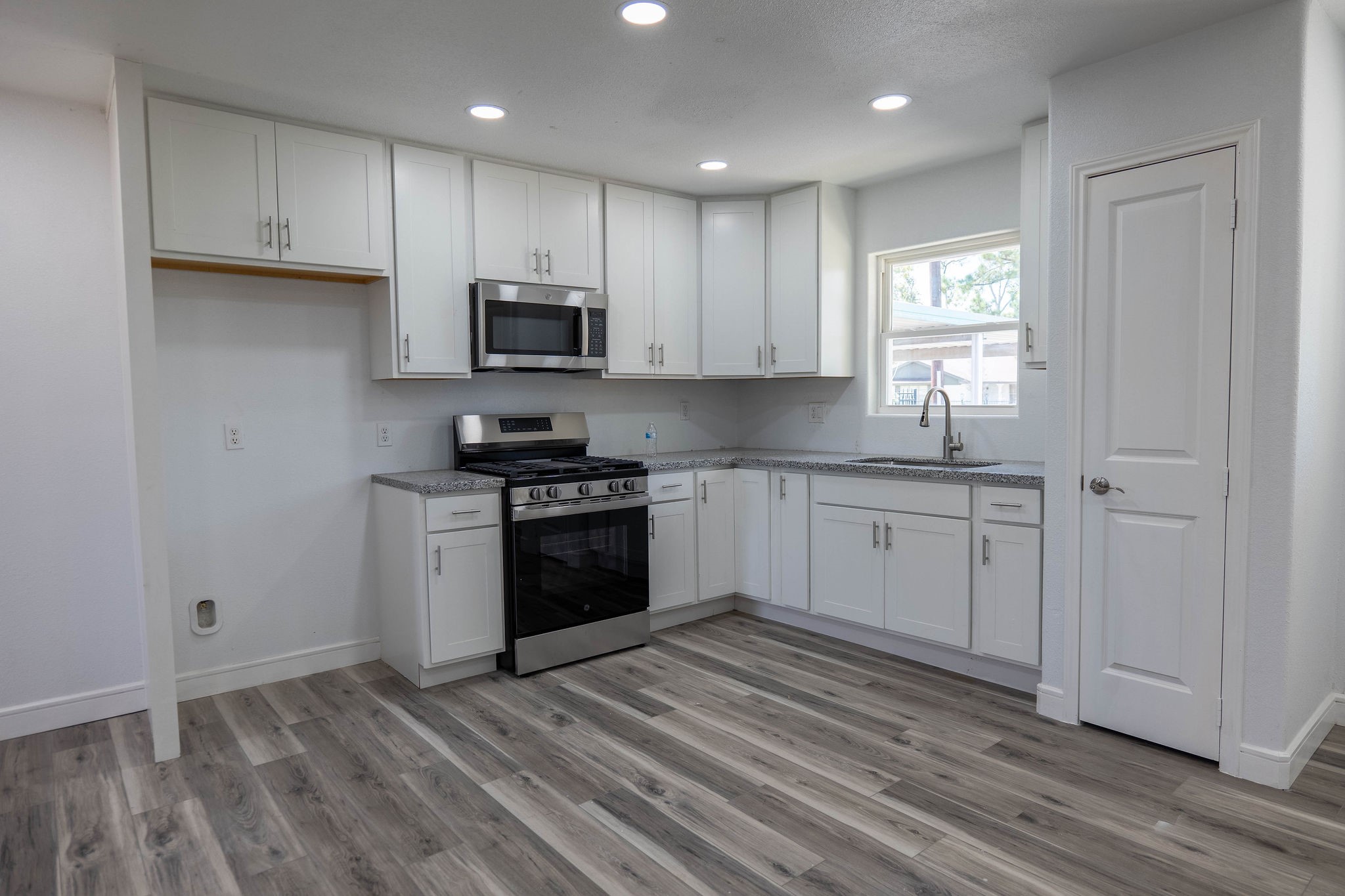 8718 Magna Street Houston, TX 77093 - Photo 5 of 33 a kitchen with granite countertop a sink cabinets and stainless steel appliances
