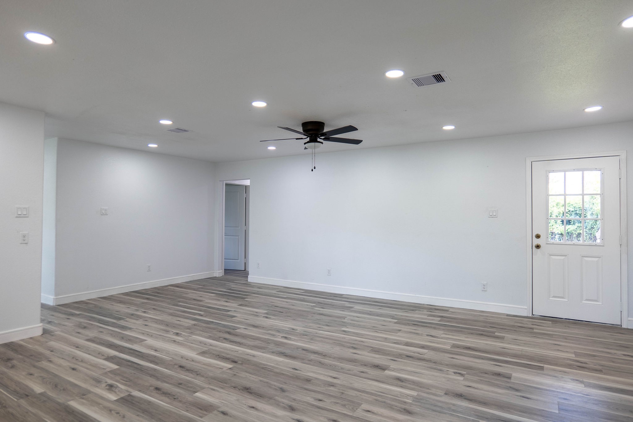 8718 Magna Street Houston, TX 77093 - Photo 9 of 33 an empty room with wooden floor and windows