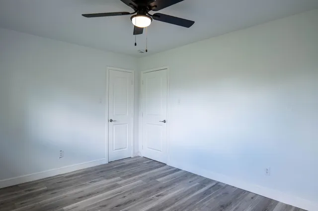 an empty room with a window and a ceiling fan