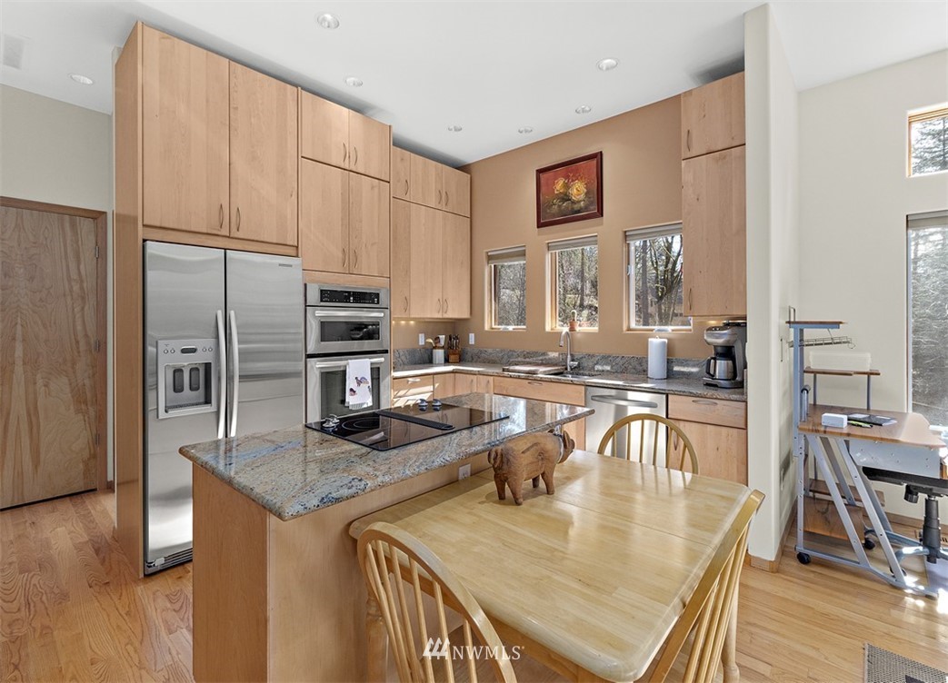 4731 Weber Road Snohomish, WA 98290 - Photo 32 of 40 a kitchen with stainless steel appliances granite countertop a stove top oven a sink a dining table and chairs
