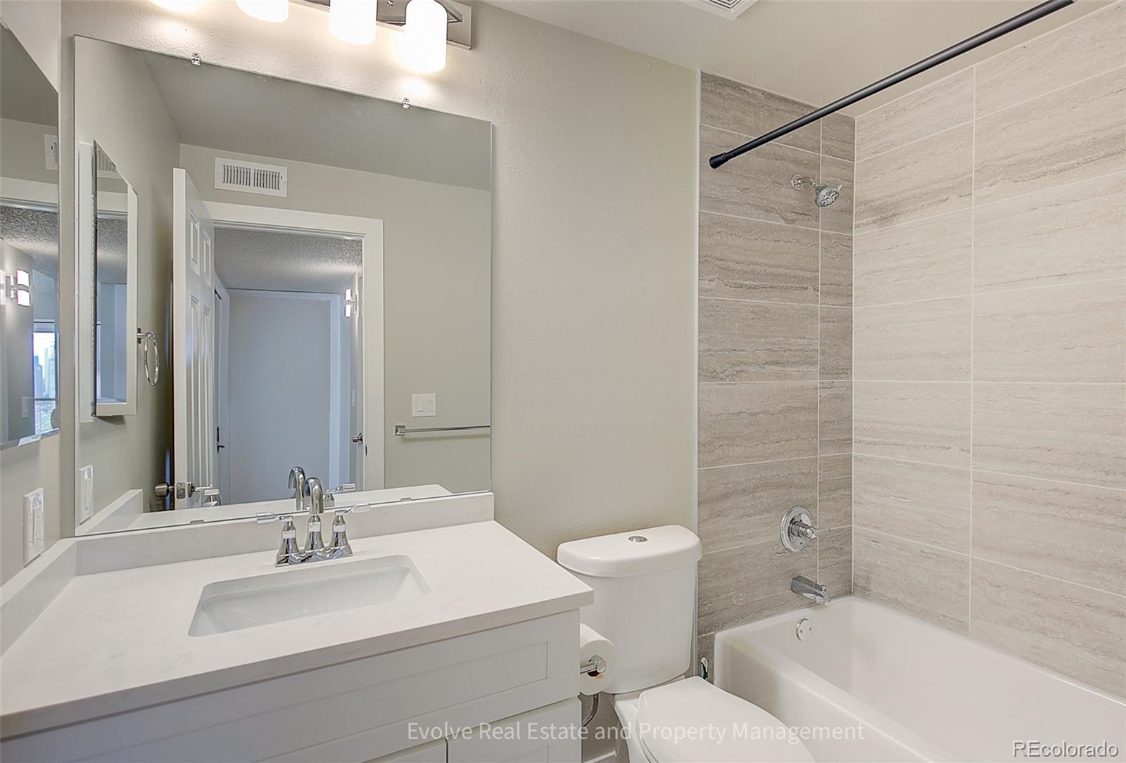 2575 South Syracuse Way, Unit J301 Denver, CO 80231 - Photo 11 of 14 a bathroom with a sink mirror toilet and bathtub