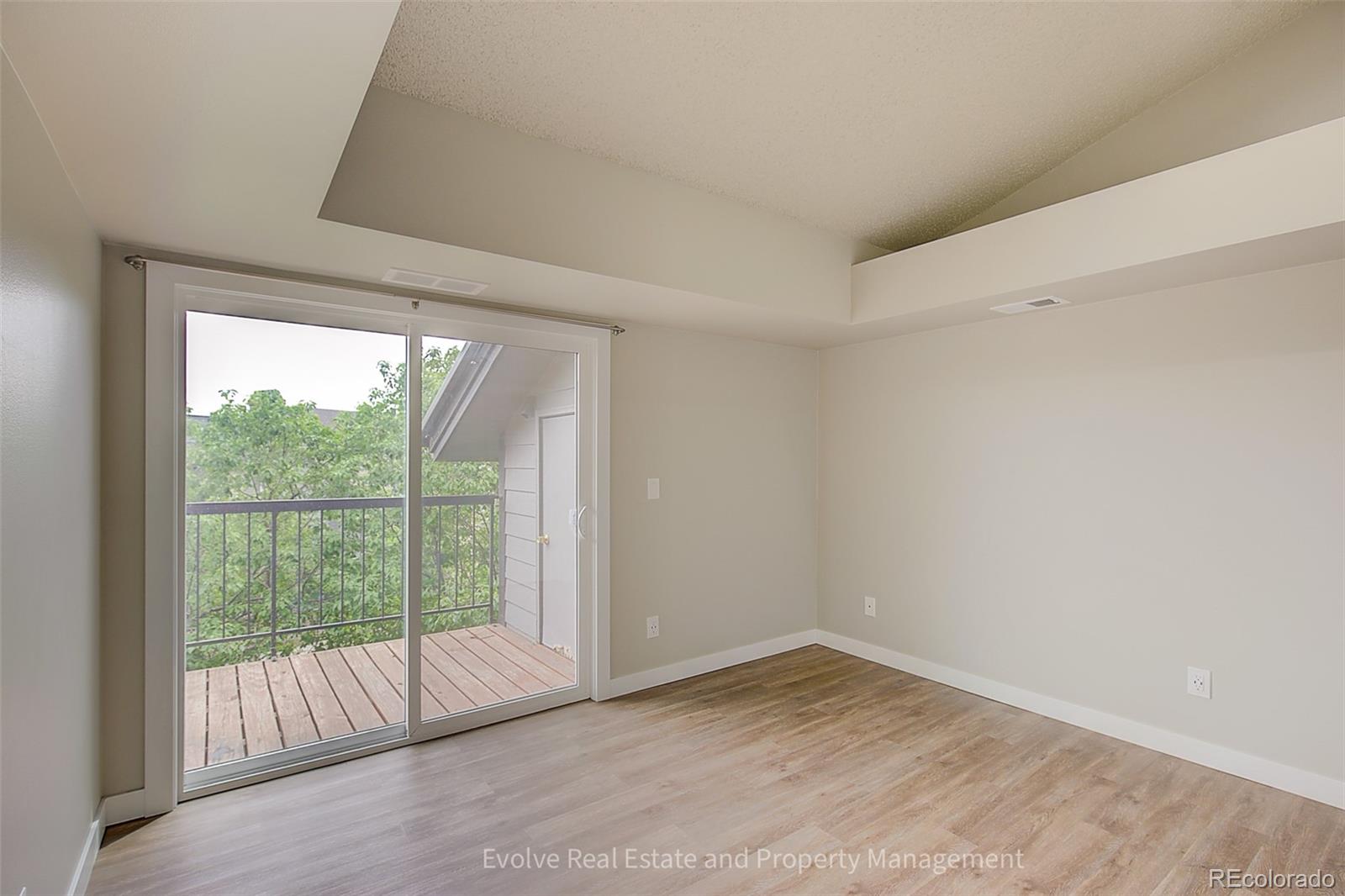 2575 South Syracuse Way, Unit J301 Denver, CO 80231 - Photo 13 of 14 a view of empty room with wooden floor and sliding door