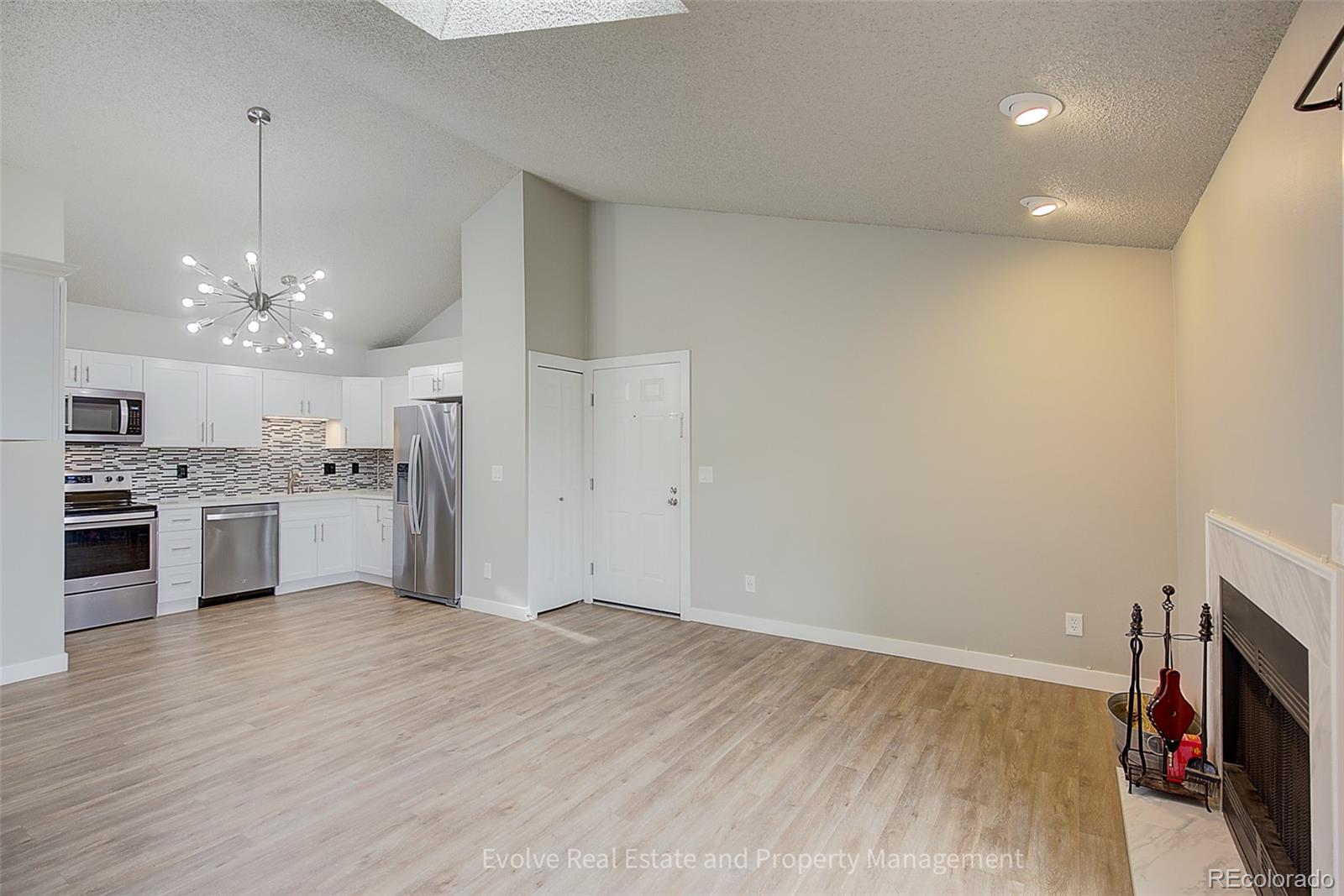 2575 South Syracuse Way, Unit J301 Denver, CO 80231 - Photo 3 of 14 a open kitchen with a sink dishwasher a stove and a refrigerator with wooden floor