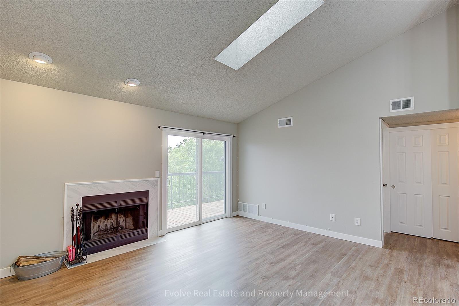 2575 South Syracuse Way, Unit J301 Denver, CO 80231 - Photo 8 of 14 a view of an empty room with wooden floor fireplace and a window