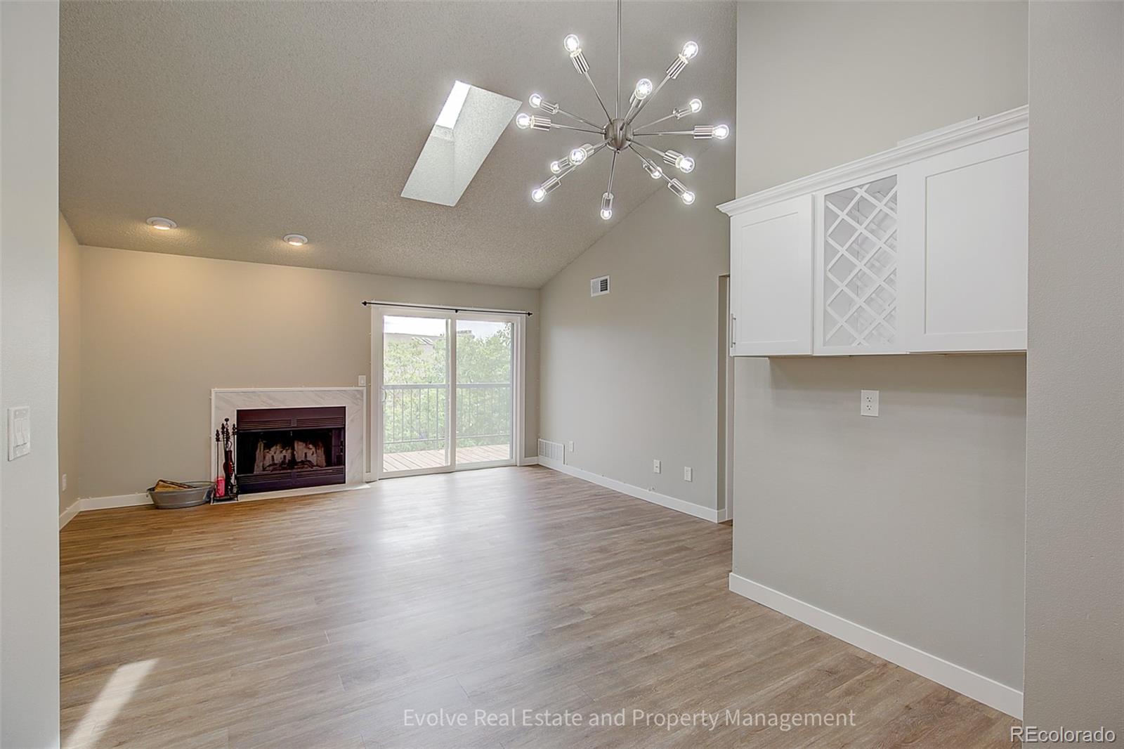 2575 South Syracuse Way, Unit J301 Denver, CO 80231 - Photo 9 of 14 a view of an empty room with wooden floor fireplace and a window