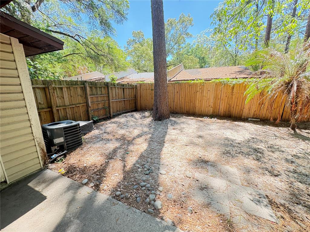 7011 Southwest 17th Place Gainesville, FL 32607 - Photo 20 of 22 a view of backyard with wooden fence and large trees