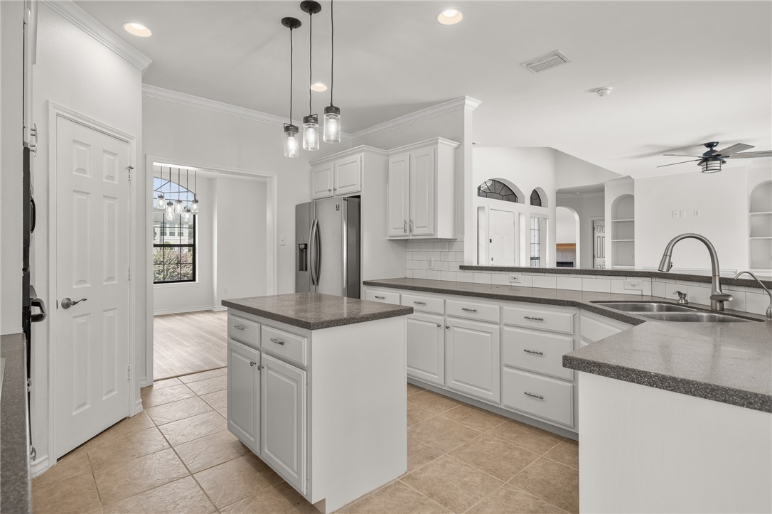 623 Broadway Boulevard Portland, TX 78374 - Photo 13 of 35 a kitchen with kitchen island granite countertop a sink and white cabinets