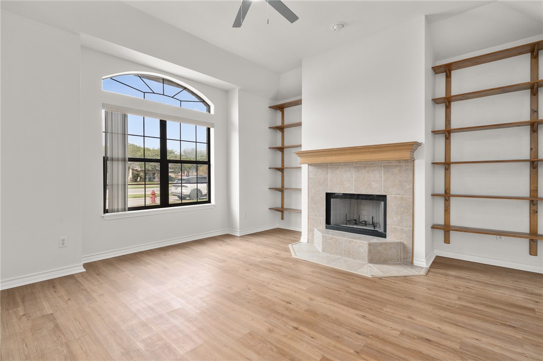 623 Broadway Boulevard Portland, TX 78374 - Photo 20 of 35 an empty room with wooden floor a fireplace and windows