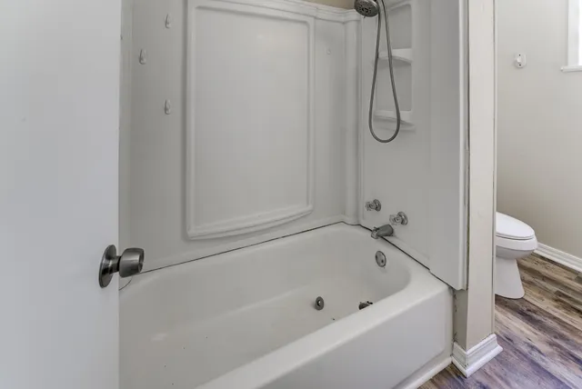 a bathroom with a bath tub with a shower