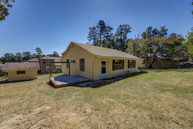 a view of a house with backyard and a tree