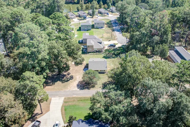 an aerial view of a house with a yard and lake view