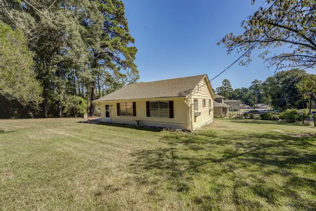 a yellow house sitting in middle of the green field