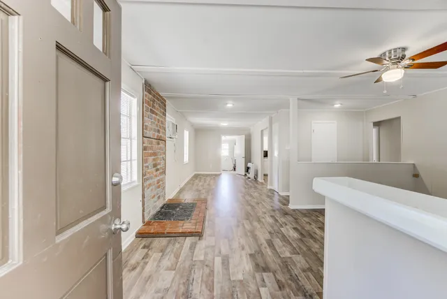 a view of a hallway with wooden floor and staircase