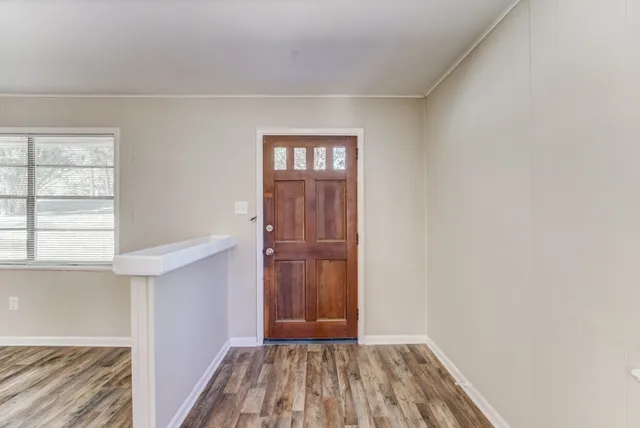 a view of a room with wooden floor and natural light