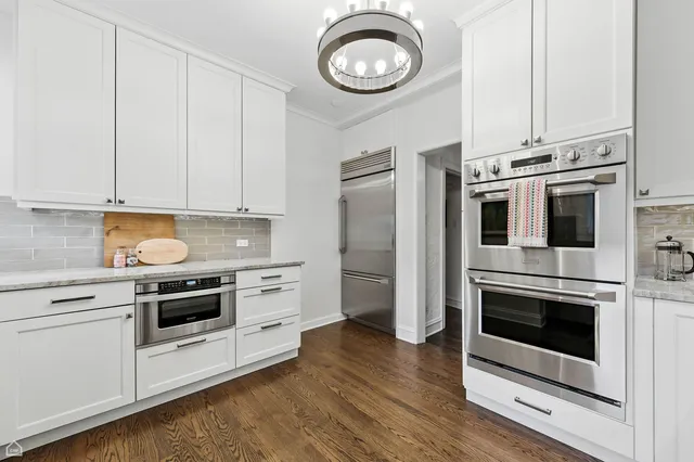a kitchen with stainless steel appliances granite countertop a stove a microwave and a white cabinets