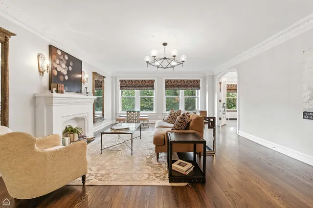 a living room with furniture chandelier and a fireplace