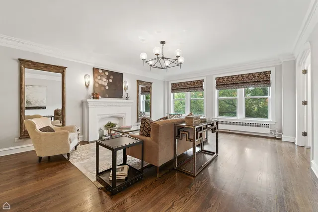 a dining room with wooden floor a chandelier a glass table and chairs