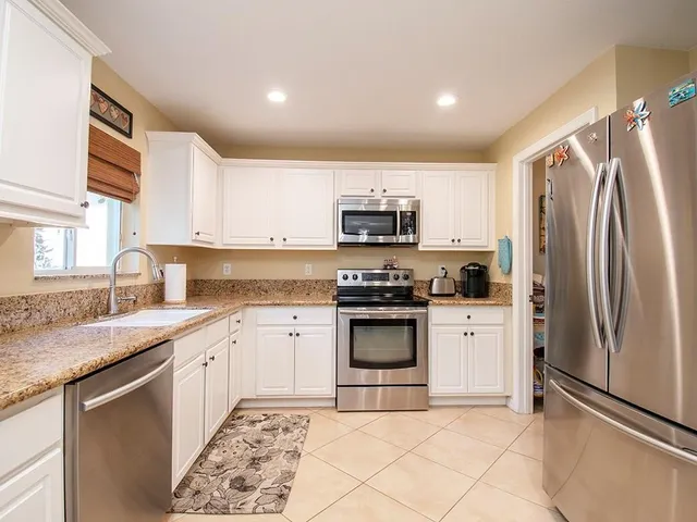 a kitchen with stainless steel appliances granite countertop a refrigerator sink and stove