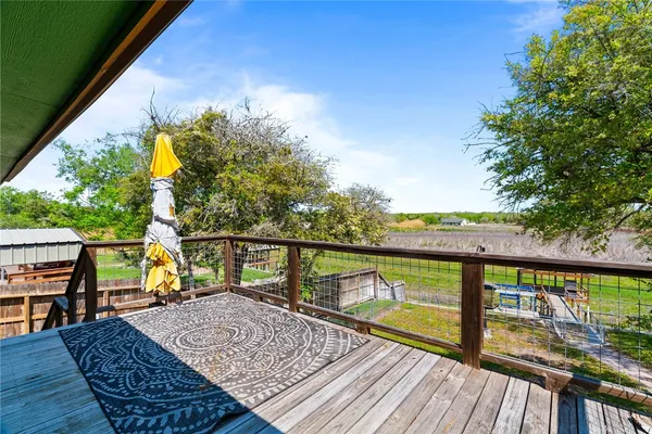 a view of a balcony with wooden floor and fence