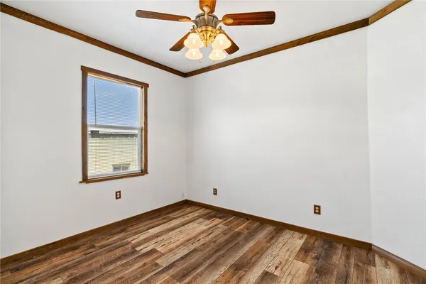 a view of empty room with window and wooden floor
