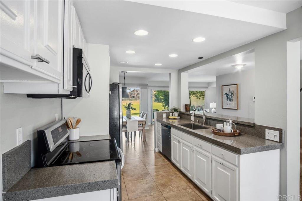 213 Via Osuna Rancho Santa Fe, CA 92091 - Photo 12 of 58 a kitchen with stainless steel appliances granite countertop a sink stove and refrigerator