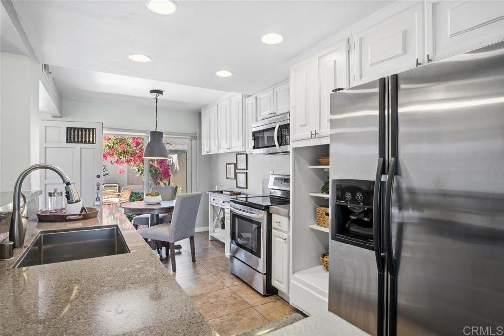 213 Via Osuna Rancho Santa Fe, CA 92091 - Photo 14 of 58 a kitchen with stainless steel appliances kitchen island granite countertop a refrigerator stove and sink