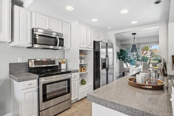 a kitchen with sink a microwave a refrigerator and cabinets