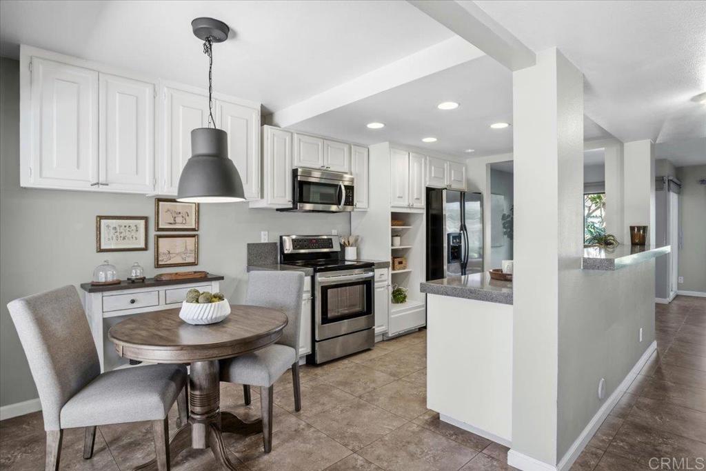 213 Via Osuna Rancho Santa Fe, CA 92091 - Photo 16 of 58 a kitchen with stainless steel appliances kitchen island granite countertop a sink a stove a refrigerator a dining table and chairs