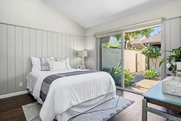 a bedroom with a bed and large windows