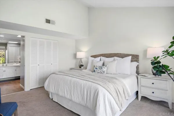a bedroom with a bed and a potted plant