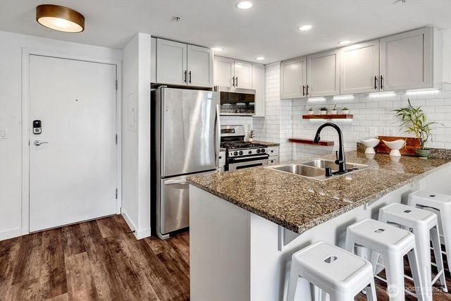 a kitchen with stainless steel appliances granite countertop a refrigerator and a sink