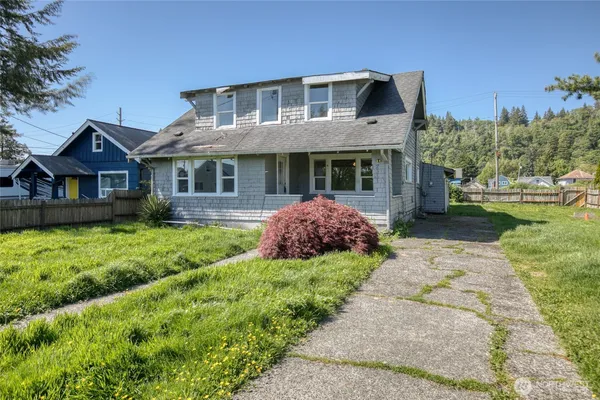 a front view of a house with a yard and potted plants
