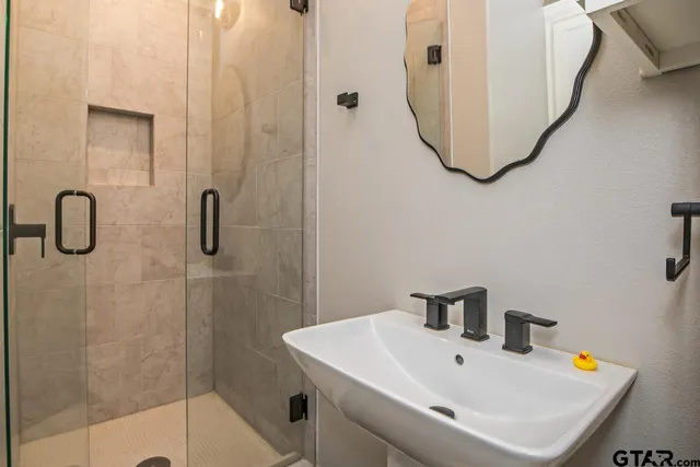 a bathroom with a sink a mirror and shower
