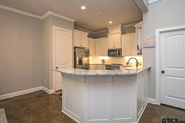 a kitchen with stainless steel appliances granite countertop a stove a sink and a refrigerator