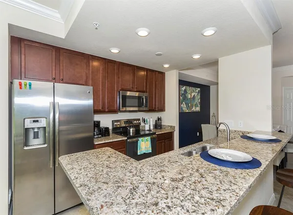 a kitchen with stainless steel appliances granite countertop a sink refrigerator and cabinets