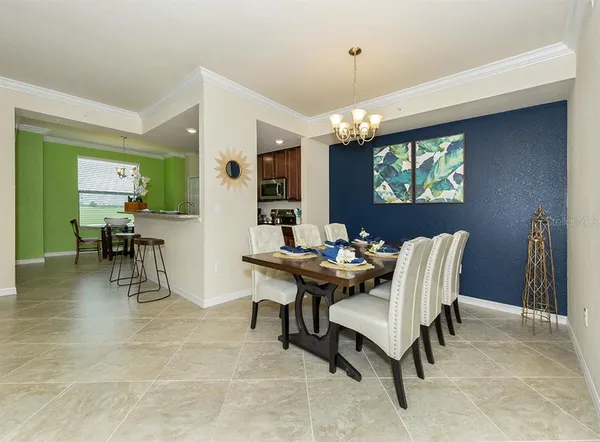 a view of a dining room with furniture a chandelier and wooden floor