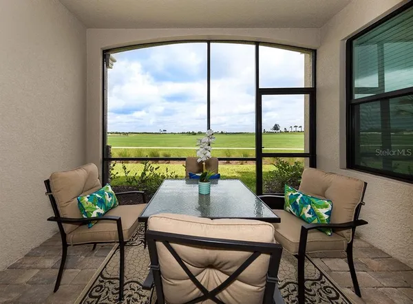 a view of a lake with lawn chairs and a table