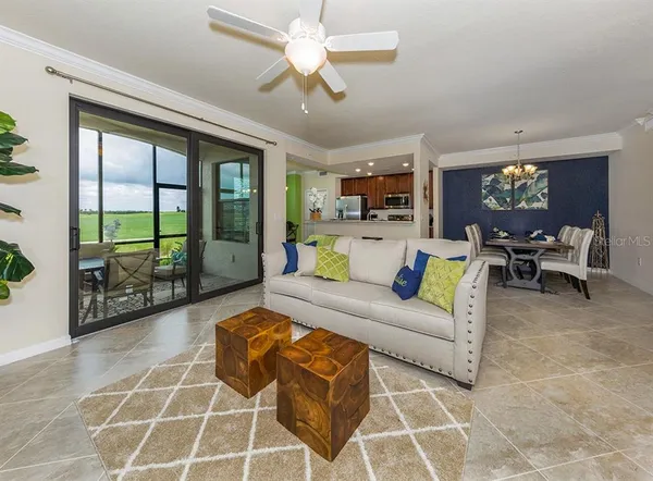a living room with furniture a flat screen tv and a floor to ceiling window