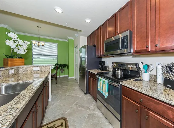 a kitchen with kitchen island granite countertop a sink stove and cabinets