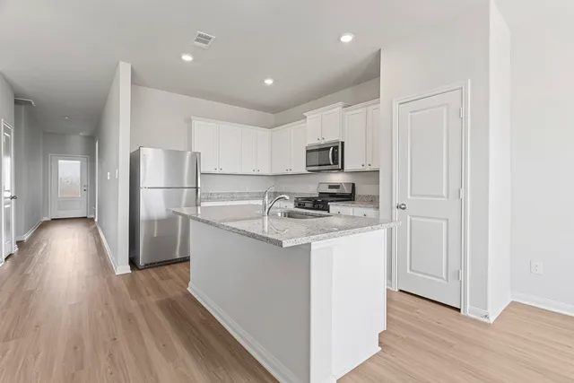 a view of an empty room with kitchen appliances and a window