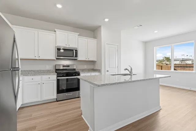 a kitchen with stainless steel appliances granite countertop a sink stove and refrigerator
