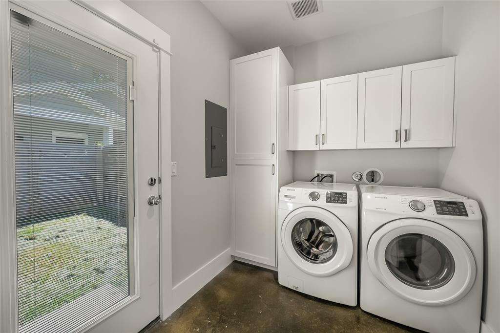 2821 Castro Street, Unit 1 Austin, TX 78702 - Photo 19 of 21 Dedicated utility space featuring a full-light door, white shaker-style cabinetry, and rich concrete-finish flooring
